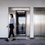 Businesswoman walking out from elevator at office lobby s